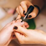 Close-up of a manicurist applying nail polish during a professional manicure session — Pandora Nail Spa, Lafayette, CA