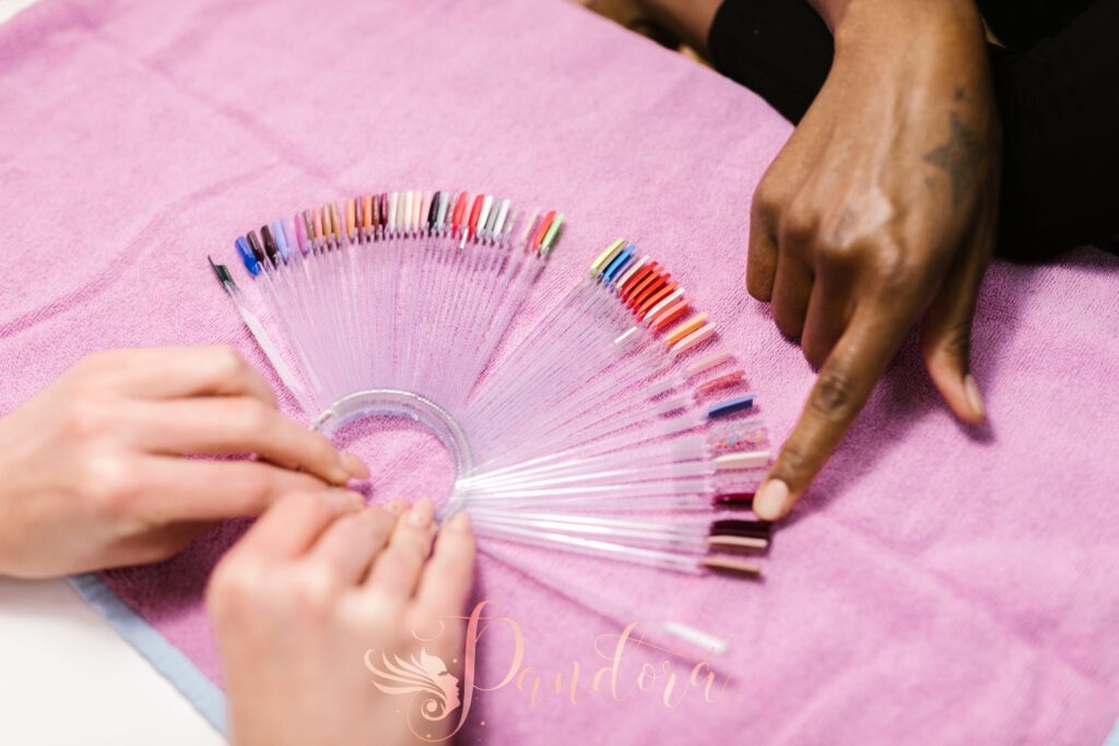 Hands selecting nail polish shades on color palette at salon — Pandora Nail Spa, Lafayette, CA