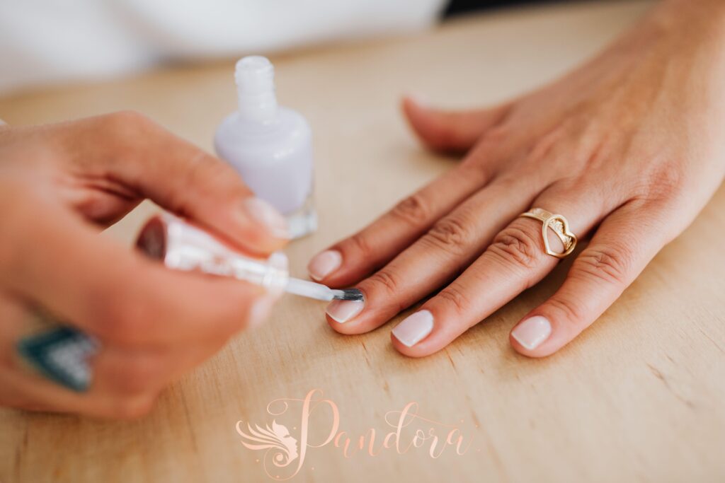 Nail technician preparing nails for long lasting prom manicure