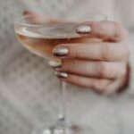 Elegant close-up of a woman's hand holding a glass of bubbly wine, showcasing glamour — Pandora Nail Spa, Lafayette, CA