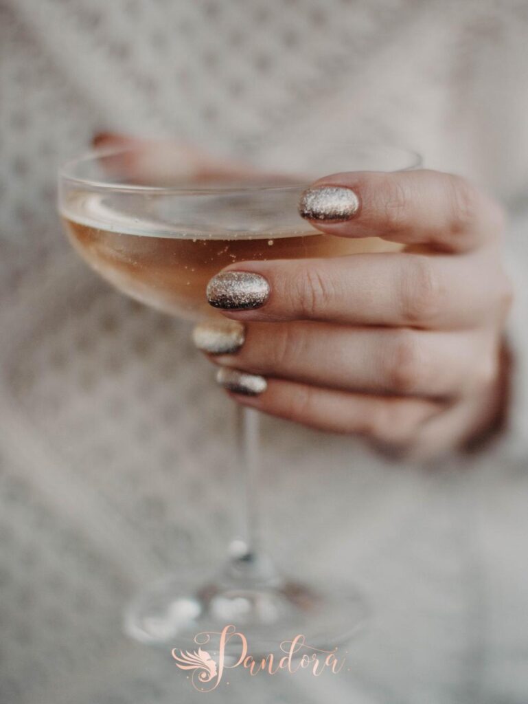 Elegant close-up of a woman's hand holding a glass of bubbly wine, showcasing glamour — Pandora Nail Spa, Lafayette, CA