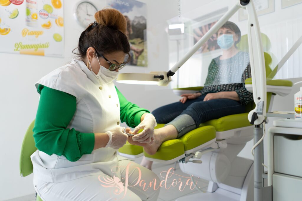 Concentrated professional master in beauty salon wearing medical mask doing pedicure during coronav — Pandora Nail Spa, Lafayette, CA