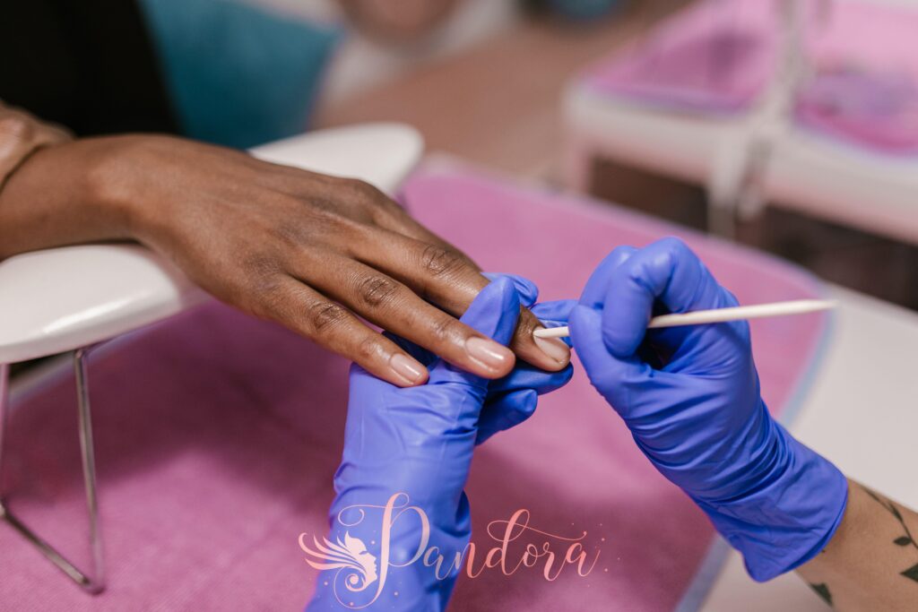 Close-up of a manicure session with blue latex gloves in a salon setting — Pandora Nail Spa, Lafayette, CA