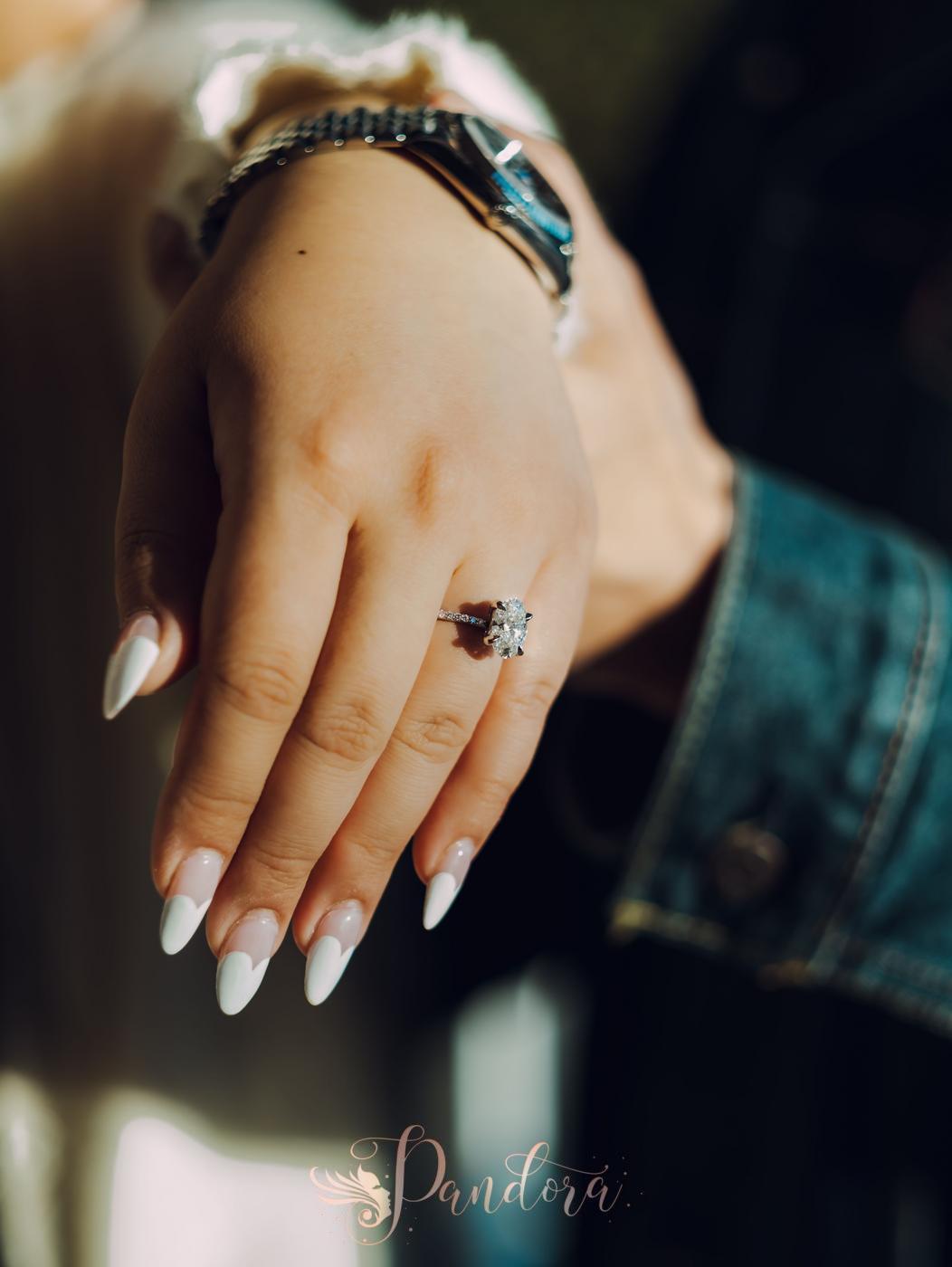 Close-up of a manicured hand showcasing a sparkling diamond ring in natural lighting — Pandora Nail Spa, Lafayette, CA