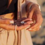 A close-up shot of a woman's manicured hands holding small beach stones and wearing a pearl ring — Pandora Nail Spa, Lafayette, CA