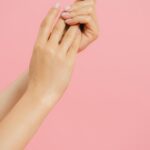 Close-up of elegant manicured hands with a pink background, showcasing nail care and beauty — Pandora Nail Spa, Lafayette, CA
