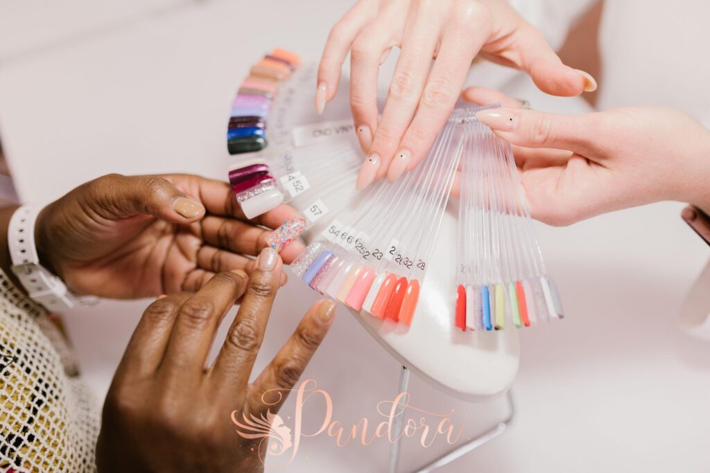 Close-up of hands choosing from a vibrant nail polish sample palette in a salon setting — Pandora Nail Spa, Lafayette, CA