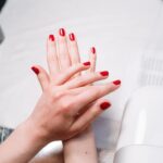 Close-up of red manicured nails during a salon session with nail tools — Pandora Nail Spa, Lafayette, CA