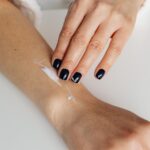 Close-up of a woman applying moisturizing cream on her forearm for skincare routine — Pandora Nail Spa, Lafayette, CA