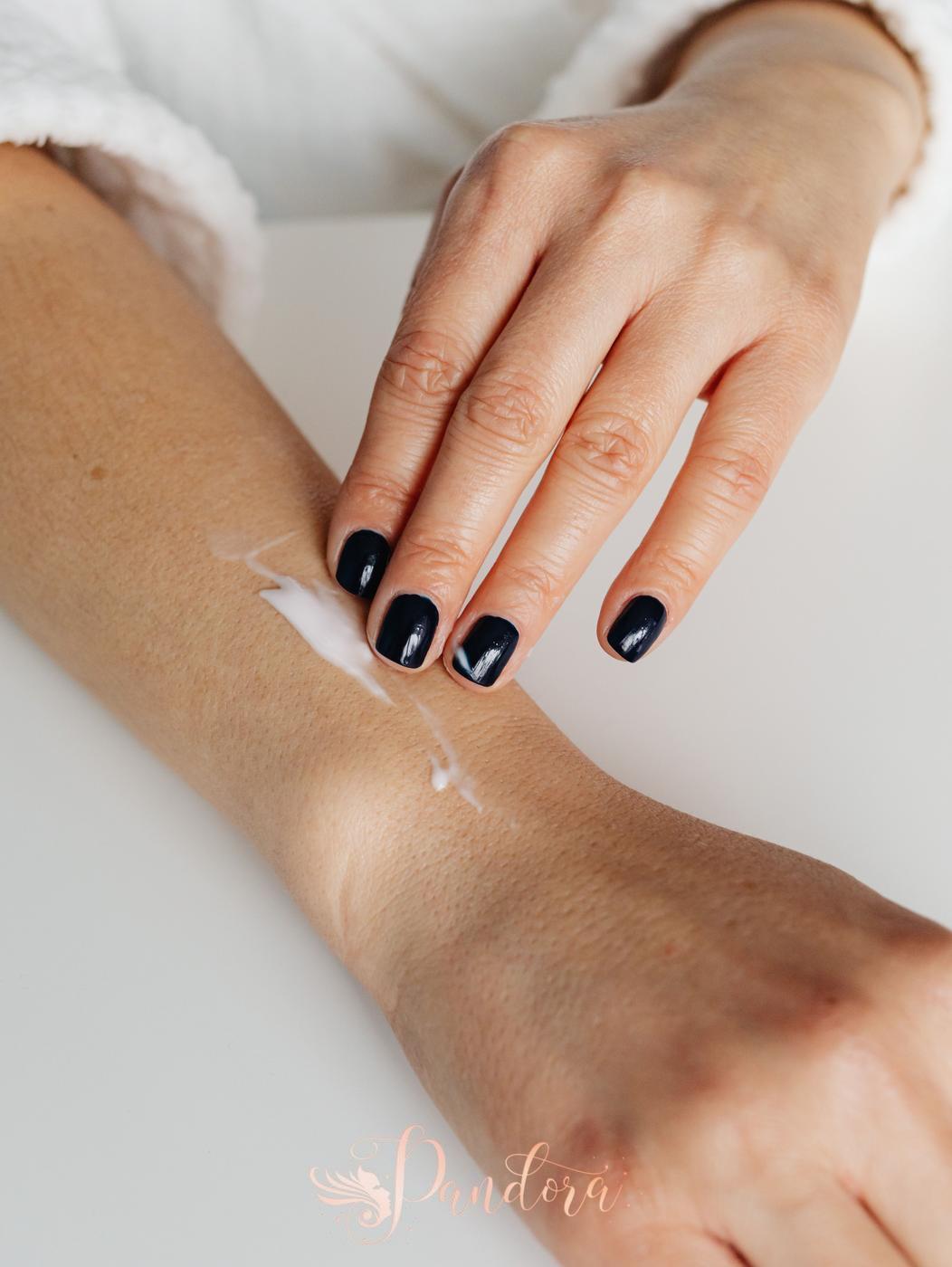 Close-up of a woman applying moisturizing cream on her forearm for skincare routine — Pandora Nail Spa, Lafayette, CA