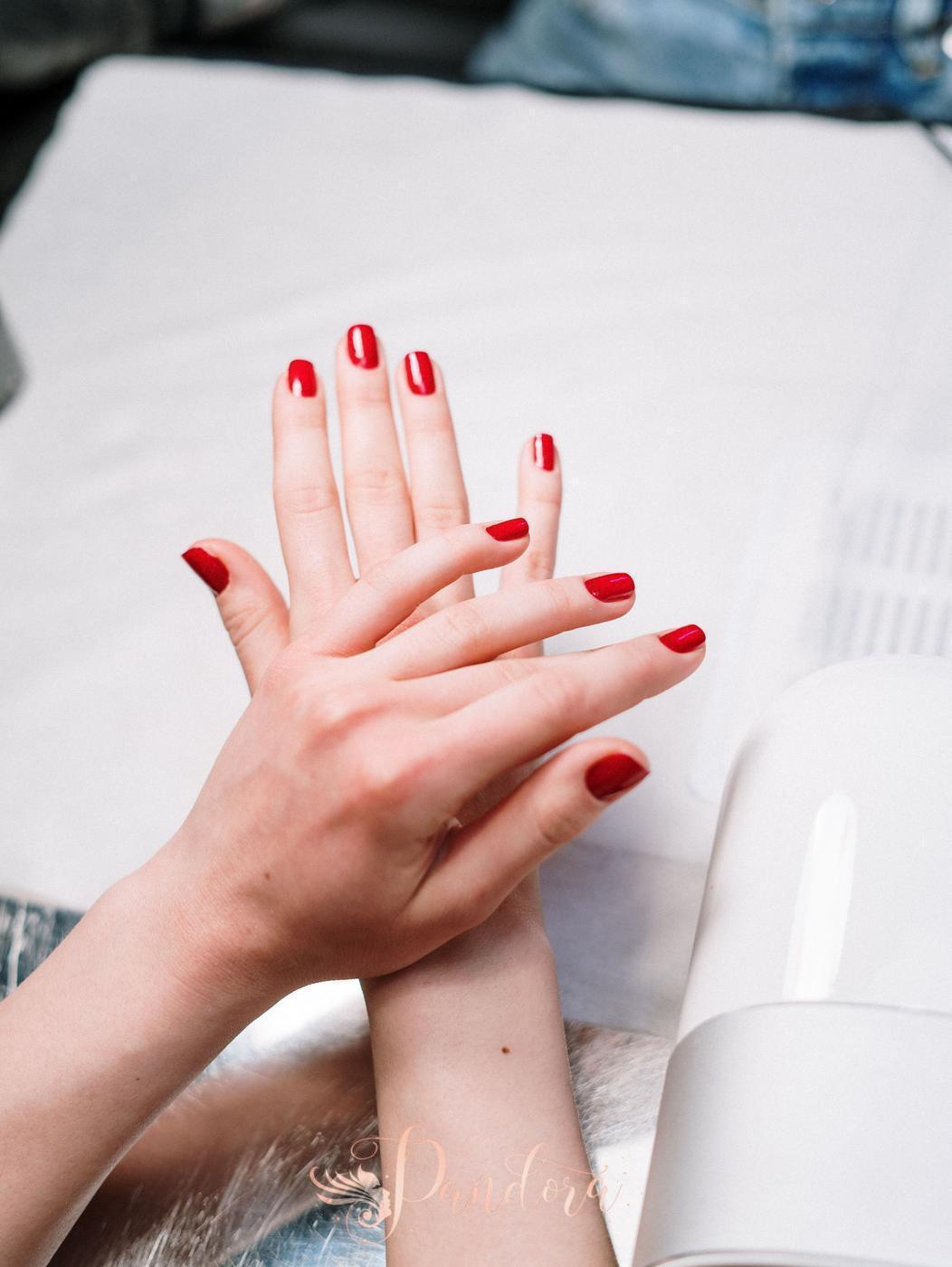Close-up of red manicured nails during a salon session with nail tools — Pandora Nail Spa, Lafayette, CA